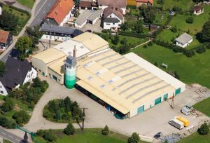 Eine Luftaufnahme einer Fabrik mit grünen Türen und beigen Dächern